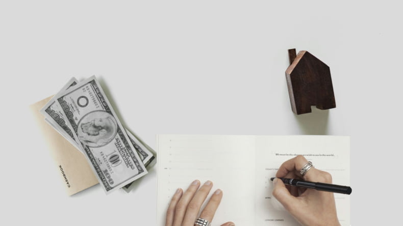Imagen de una persona firmando la compra de una casa de obra nueva junto al primer pago fijo