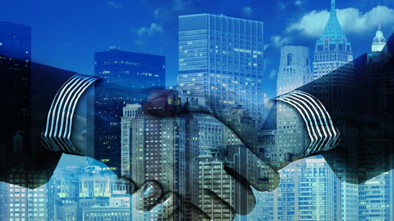 Imagen de dos manos en señal de acuerdo de colaboración entre promotora y agencia inmobiliaria