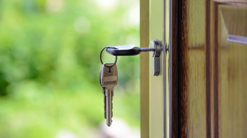 Imagen de una persona abriendo una casa, tras calcular el valor catastral antes de comprarla