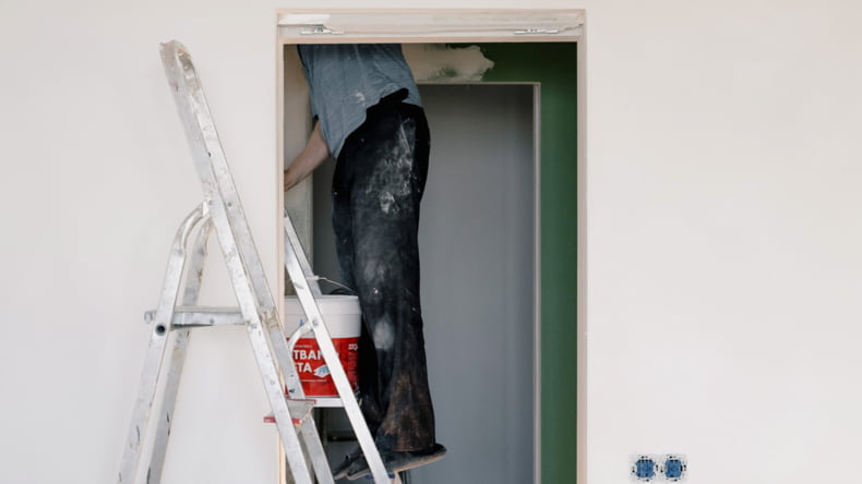 Imagen de una persona reparando los desperfectos de una casa que están incluidos en la garantía obligatoria y el seguro decenal