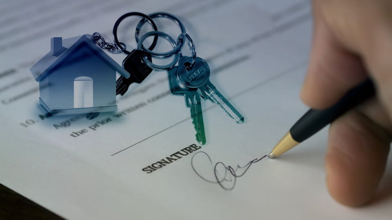 Imagen de una persona firmando un documento que simboliza la compraventa de una casa, ejerciendo el derecho de tanteo y de retracto