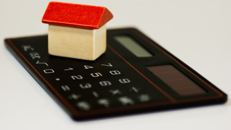 Imagen de una casa y una calculadora como muestra de qué hipoteca elegir en 2023