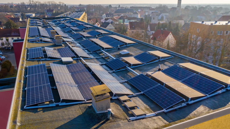 Imagen de sistemas de placas solares en un edificio de casas de obra nueva