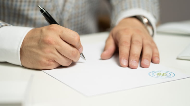 Un hombre firmando unas escrituras